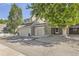 Traditional townhome showcasing a two-car garage, tidy landscaping, and charming curb appeal at 10685 W Apishapa Pass, Littleton, CO 80127