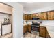 Compact kitchen area features stainless steel appliances, bright countertops, and a convenient laundry closet at 10685 W Apishapa Pass, Littleton, CO 80127