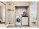 Efficient laundry area featuring a modern washer and dryer, shelving, and convenient access to the bathroom at 10685 W Apishapa Pass, Littleton, CO 80127