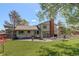 Large backyard with a deck, seating area, mature trees, and a well-kept lawn at 7877 W 110Th Dr, Westminster, CO 80021