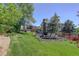 Well-manicured backyard with a deck, a vegetable garden, and mature trees at 7877 W 110Th Dr, Westminster, CO 80021