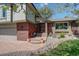 Inviting home exterior featuring brick accents, a cozy front porch, and a well-maintained garden at 7877 W 110Th Dr, Westminster, CO 80021