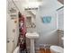 Modest bathroom with a pedestal sink, bathtub/shower, and a window at 253 N Lincoln St, Denver, CO 80203