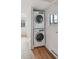 Bright laundry room with stacked washer and dryer, window, and neutral paint at 253 N Lincoln St, Denver, CO 80203
