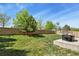 Lush green backyard with stone retaining wall and outdoor seating area at 20928 E Hamilton Ave, Aurora, CO 80013