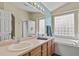 Bright bathroom features double sinks, a glass block window, and a separate tub and shower at 20928 E Hamilton Ave, Aurora, CO 80013