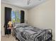 Cozy bedroom features an iron bed frame, a decorative quilt, and a window with dark curtains at 20928 E Hamilton Ave, Aurora, CO 80013