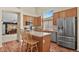 Well-lit kitchen featuring stainless steel appliances, wooden cabinetry, and a functional island with seating at 20928 E Hamilton Ave, Aurora, CO 80013