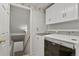 Laundry room featuring white cabinets and modern washer and dryer with a stairway leading to the basement at 20928 E Hamilton Ave, Aurora, CO 80013