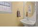 This powder room has a round mirror and a pedestal sink with nice natural lighting at 20928 E Hamilton Ave, Aurora, CO 80013