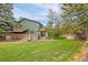 Expansive backyard with mature trees, lush lawn, privacy fence, and a patio area perfect for outdoor enjoyment at 7655 S Olive Cir, Centennial, CO 80112