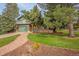 Charming home with brick and siding, a well-maintained lawn, and a stone walkway leading to the front door at 7655 S Olive Cir, Centennial, CO 80112