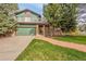 Charming home featuring a two-car garage, second story balcony, and a brick-lined walkway at 7655 S Olive Cir, Centennial, CO 80112