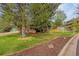 Charming home with a green lawn, mature trees, a decorative rock border, and a welcoming curb appeal at 7655 S Olive Cir, Centennial, CO 80112