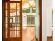 Sunlit living room with hardwood floors, vaulted ceilings, and French doors leading to the backyard at 7655 S Olive Cir, Centennial, CO 80112