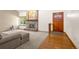 Cozy living room with a brick fireplace, wooden door, and a combination of carpet and hardwood floors at 7655 S Olive Cir, Centennial, CO 80112