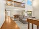 Spacious living room featuring a large sectional couch, high ceilings, and beautiful hardwood floors at 7655 S Olive Cir, Centennial, CO 80112