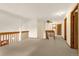 Open and airy loft area with neutral carpet, wooden railings, and multiple doorways leading to other rooms at 7655 S Olive Cir, Centennial, CO 80112