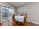 Bright dining area with hardwood floors, a window, and a sliding glass door to the back yard at 5131 Delphinium Cir, Brighton, CO 80601
