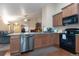 Open kitchen featuring granite countertops, stainless steel appliances, and wood cabinetry at 5131 Delphinium Cir, Brighton, CO 80601
