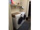 Laundry area with a washer, dryer, storage shelf, and dark blue mat at 5131 Delphinium Cir, Brighton, CO 80601