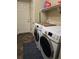 Laundry room with modern washer and dryer units and storage at 5131 Delphinium Cir, Brighton, CO 80601