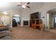 Comfortable living room with a fireplace, ceiling fan, media center, and arched entryway at 5131 Delphinium Cir, Brighton, CO 80601