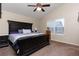 The main bedroom features a dark wood king bed, ceiling fan, and natural lighting at 5131 Delphinium Cir, Brighton, CO 80601