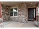 Inviting front porch with stone detailing and a secure, dark wood front door at 5131 Delphinium Cir, Brighton, CO 80601