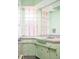 Stylish mint green bathroom with retro tile and glass block window at 6600 E 4Th Ave, Denver, CO 80220