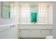 Bright bathroom with modern glass block window and white vanity at 6600 E 4Th Ave, Denver, CO 80220
