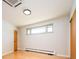 Clean bedroom with hardwood floors, modern recessed lighting, and baseboard heaters at 6600 E 4Th Ave, Denver, CO 80220