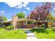 Charming brick home featuring a well-manicured lawn, mature trees, and a welcoming walkway at 6600 E 4Th Ave, Denver, CO 80220