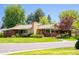 Street view of a brick home with a well-kept lawn and mature trees at 6600 E 4Th Ave, Denver, CO 80220