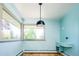 Light-filled living room with large windows, wood floors, and built-in desk at 6600 E 4Th Ave, Denver, CO 80220