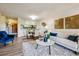 Open-concept living room with cozy seating, decorative artwork, and seamless transition to the dining area at 7420 E Quincy Ave # 304, Denver, CO 80237