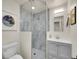 Modern bathroom featuring marble tile shower, a toilet, a mirror, and a gray vanity with cabinet at 755 S Milwaukee St, Denver, CO 80209