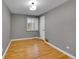 Empty bedroom with hardwood floors, grey walls, white trim and a large window letting in natural light at 755 S Milwaukee St, Denver, CO 80209