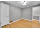 Well-lit empty bedroom with hardwood floors, grey walls, white trim and two white doors at 755 S Milwaukee St, Denver, CO 80209