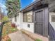 A home exterior featuring mature landscaping, a black metal security door, and updated windows at 755 S Milwaukee St, Denver, CO 80209