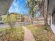 Lush front yard with a stone walkway, mature trees, and a glimpse of neighboring houses, all enclosed by a black iron fence at 755 S Milwaukee St, Denver, CO 80209