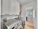 Laundry room with large capacity washer and dryer and cabinets for storage space at 755 S Milwaukee St, Denver, CO 80209