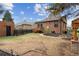 Charming backyard with brick house, wooden fence, small patio area, and mature trees for privacy at 2910 Clermont St, Denver, CO 80207