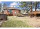Expansive backyard featuring a brick house, wooden fence, landscaped garden area, and covered outdoor structure at 2910 Clermont St, Denver, CO 80207