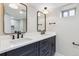 Modern bathroom features a double vanity with dark cabinets, sleek fixtures, mirrors, and a subway tile backsplash at 2910 Clermont St, Denver, CO 80207