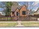 Charming brick home featuring a well-manicured lawn and a quaint picket fence at 2910 Clermont St, Denver, CO 80207