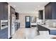 Bright kitchen features navy cabinets, stainless steel appliances, and light hardwood floors at 2910 Clermont St, Denver, CO 80207