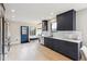 Spacious kitchen features navy cabinets, stainless steel appliances and a blue exterior door at 2910 Clermont St, Denver, CO 80207