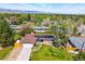 Panoramic aerial view of the property showcasing the home with solar panels, surrounding trees, and mountain backdrop at 11715 W 30Th Pl, Lakewood, CO 80215