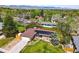 Aerial view of a house with solar panels, a fenced yard, and lush green surroundings at 11715 W 30Th Pl, Lakewood, CO 80215